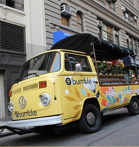 Colorful flower truck parked on urban street.
