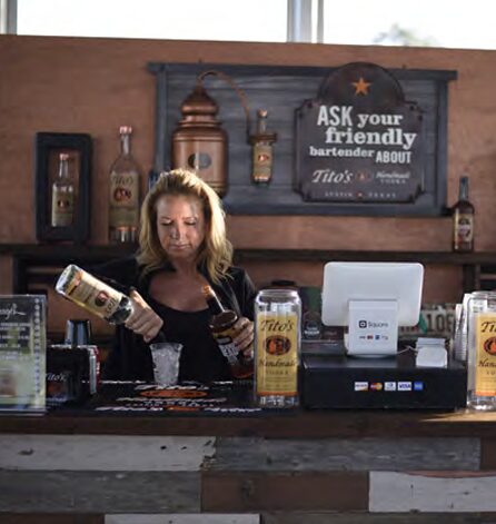 Bartender mixing drinks at a bar counter.